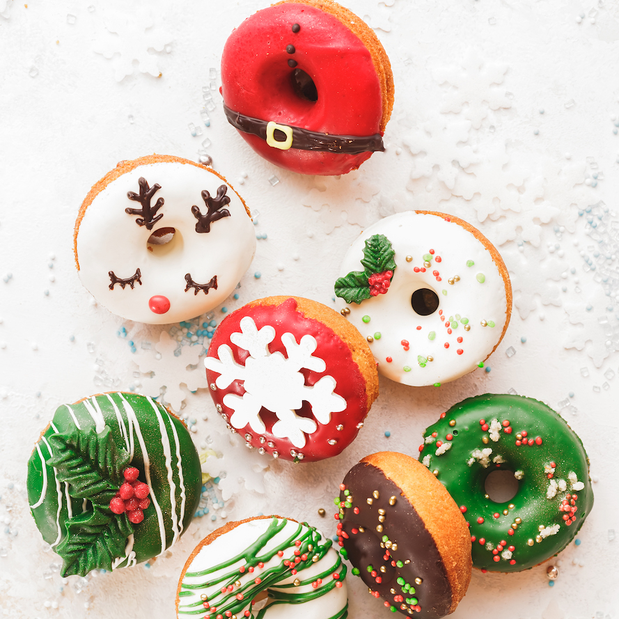 Christmas Donuts. Assorted Homemade Glazed Donuts With Sprinkles On White Festive Background